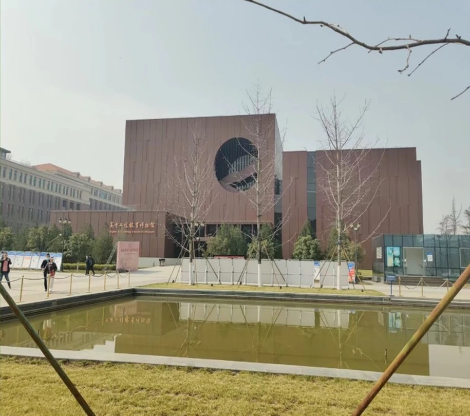 Minimalist university building with surrounding road and water feature